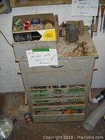 Overview of grinder mounted on gray metal cabinet with multiple labeled drawers and a note indicating grinder with cabinet and drawers.