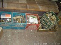 Four milk crates filled with assorted door hardware including knobs and locks