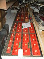 Overview of long red-painted wooden cabinet with multiple small drawers