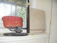 Surveyor's transit mounted on a circular black metal base next to a paper cutting mat