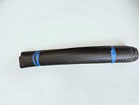 Rolled black rubber diamond plate flooring showing texture and overall condition