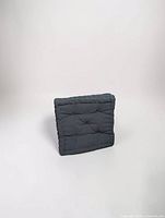 front view of blue-gray square seat cushion showing tufting and edges
