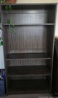 Front view of bookcase showing four shelves and wood-grain finish