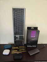 Group shot of keyboard, RAM sticks, hub, charging station box, earbud cases