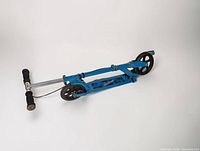 Scooter folded showing blue deck, silver handlebar with foam grips, large front and rear wheels