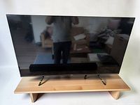 Front view of 55" Hisense TV on stand