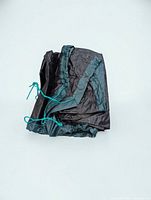 folded black side of tarp with teal drawstring visible