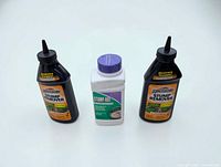 Front view of three stump remover chemical bottles: two Spectracide and one Stump-Out