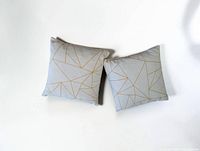 Front view of both pillows showing gold geometric pattern