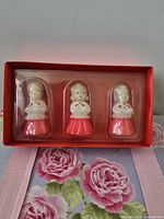 Open box showing three unused caroler candles in plastic insert
