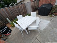 Entire dining set showing table and four chairs outdoors