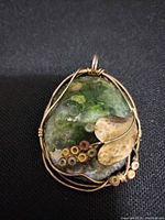 Front view showing stone colour, brass leaf and discs, wire wrap