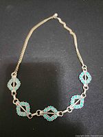 Front view of full necklace showing turquoise stone stations and chain