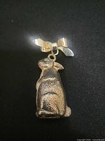 front view of silver-tone rabbit rattle brooch on black background