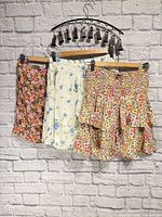 Three floral mini skirts hanging on rack