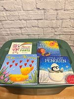 Front covers of all four board books laid out on a green surface