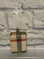Front view of Burberry London perfume bottle showing plaid fabric wrap and atomizer