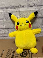 Front view of yellow corduroy Pikachu plush showing facial embroidery and overall condition