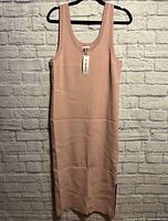 Front view of blush pink sleeveless ribbed midi dress hanging, tag visible