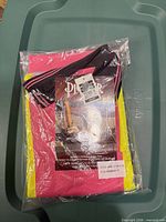 Packaged pink and yellow safety polo in bag with Pioneer tag visible