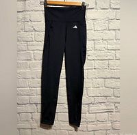 Front view full length of navy Adidas leggings hanging