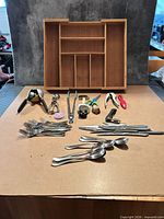 Lot overview showing bamboo organizer, flatware, kitchen tools