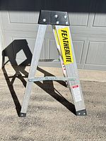 Full view of Featherlite aluminum step stool ladder with side label visible
