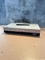 Front view of LG DVD/VCR combo with remote on top and power cord visible