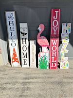 Group shot of all six porch signs leaning against wall