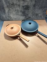 Both pans with lids side by side showing colours, sizes and overall condition