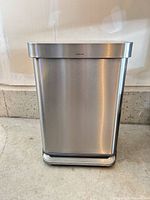Front view of rectangular stainless steel Simplehuman step pedal trash can