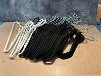 Group of black velvet and white plastic hangers on tabletop