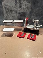 Spiralizer, two red blade plates, three clear containers with lids