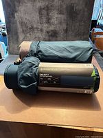 Rolled Woods Max Rest 4 pad in carry wrap beside secondary view of pad