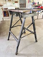 Full angled view of folding sawhorse workbench showing frame, top and overall condition