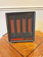 Front view of Micromar The Heat Machine infrared heater showing mesh grille, heating elements, and branding