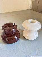 Both porcelain insulators side by side showing color and style difference