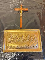Front view of gold-tone Last Supper plaque and wooden crucifix