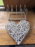 Wicker heart and metal rack side by side on workbench