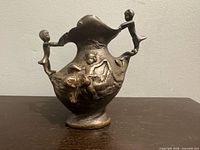 Full view of bronze jug vase front with figural relief and handles