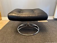 Top view of black leather Stressless ottoman showing button-tufted cushion