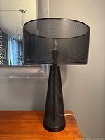 Full view of lamp showing conical base and perforated drum shade