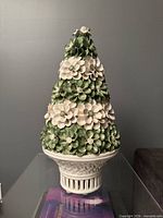 Full view of ceramic floral topiary showing overall form and pedestal base