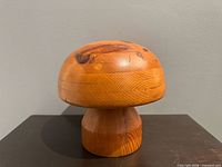 front view of wooden hat mould on dark surface