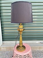 Full view of brass-finish table lamp with black drum shade