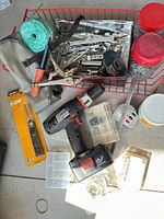 Overall lot showing drill, hand tools, jars, accessories in red basket