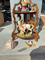 Overall lot showing shelf, figurines, seashell, wind chime parts