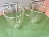 Two clear double-wall glass mugs on surface