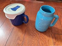 Both mugs side by side on wood floor