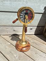 Full view of brass and wood engine room telegraph on wooden surface
